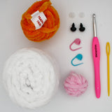 beginner crochet kit Bella the bunny materials including training yarn, chenille yarn for bunny, stitch markers, safety eyes, darning needle, and crochet hook.