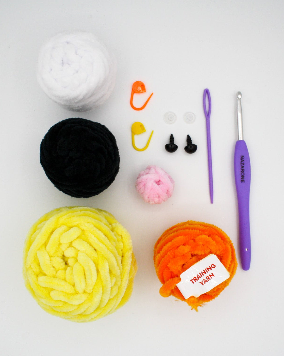 beginner crochet kit materials including training yarn, bee plushie yarn, stitch markers, safety eyes, darning needle, crochet hook