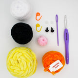 beginner crochet kit materials including training yarn, bee plushie yarn, stitch markers, safety eyes, darning needle, crochet hook