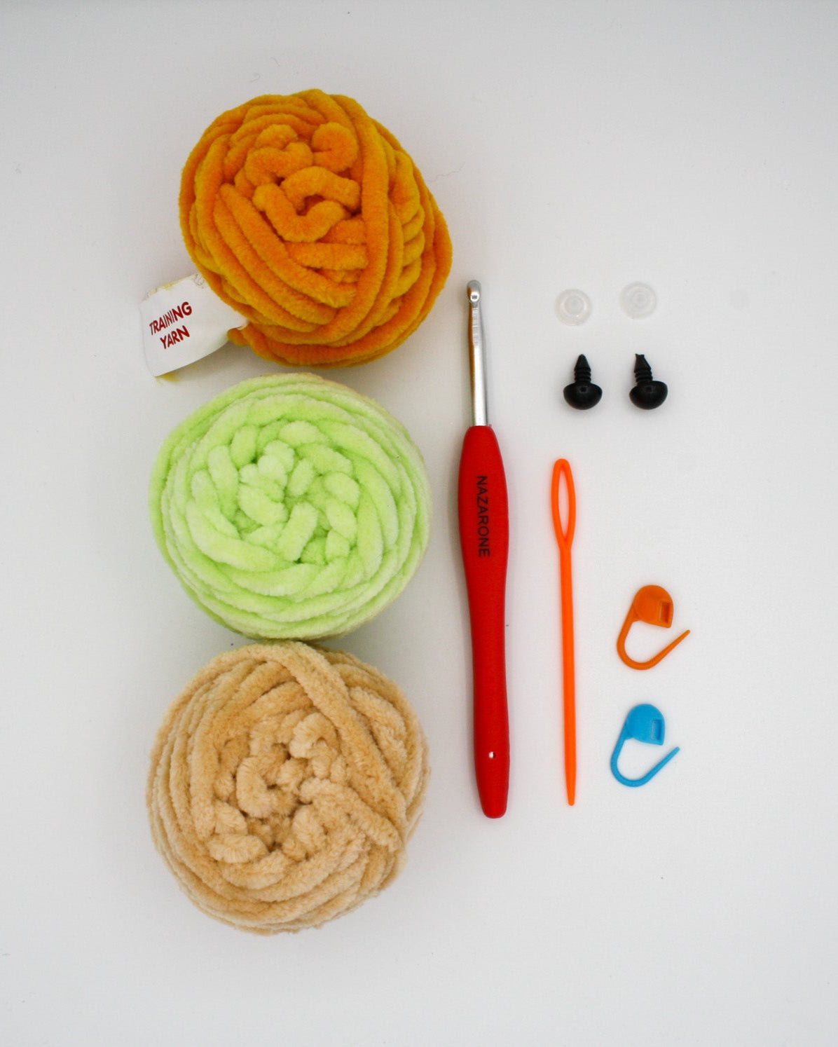 beginner crochet kit toby the turtle materials including training yarn, chenille yarn for turtle, stitch markers, darning needle, safety eyes, and crochet hook.