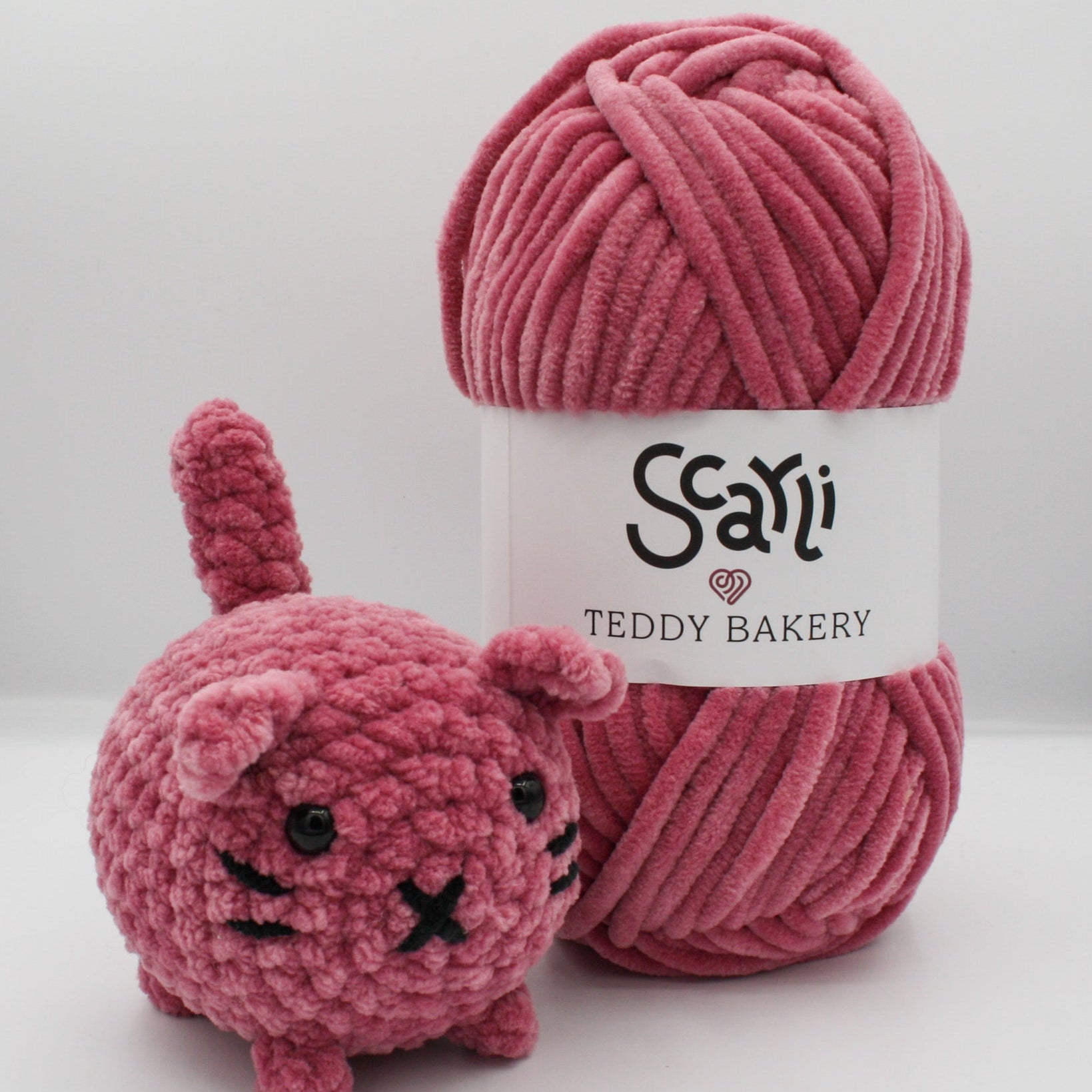 skein of rose chenille plush yarn with amigurumi crochet cat plushie pink