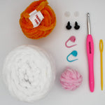 beginner crochet kit Bella the bunny materials including training yarn, chenille yarn for bunny, stitch markers, safety eyes, darning needle, and crochet hook.