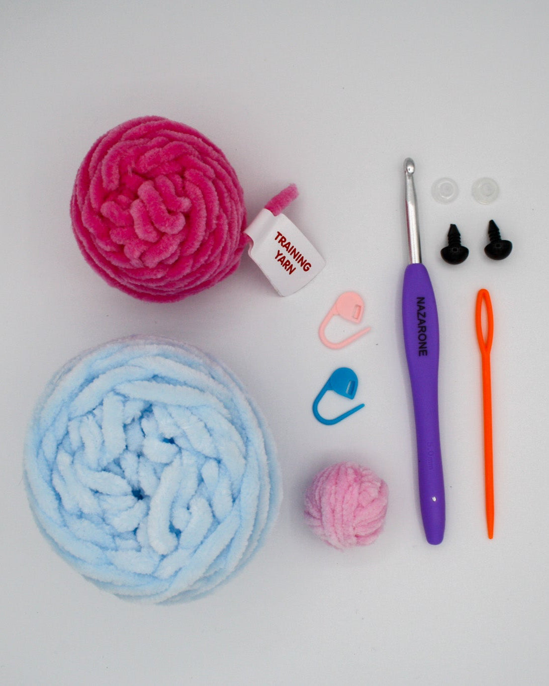 beginner crochet kit Ozzy the octopus materials including tester yarn, octopus chenille yarn, stitch markers, darning needle, safety eyes, and crochet hook.