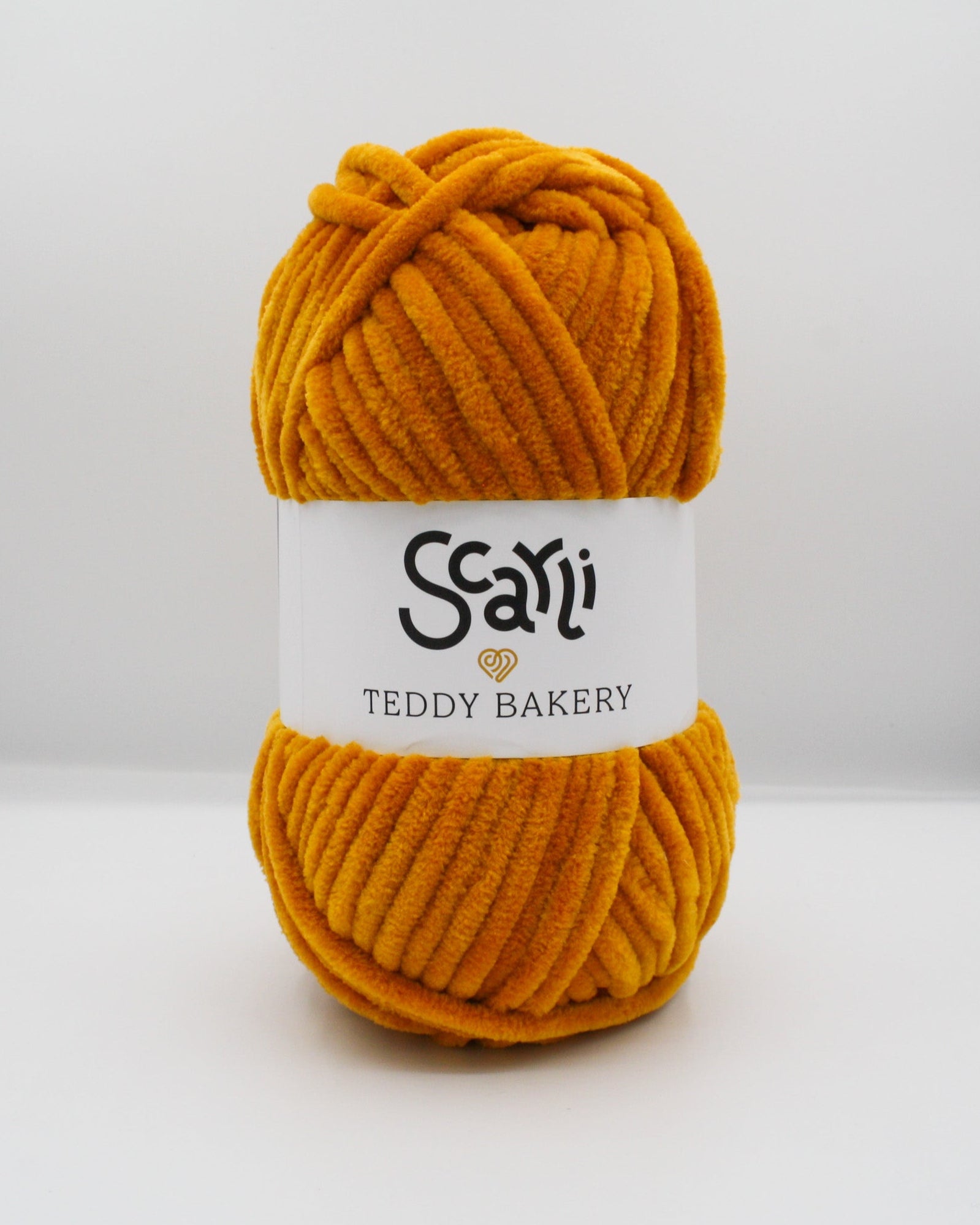 dark golden orange skein of chenille plush yarn called Teddy Bakery